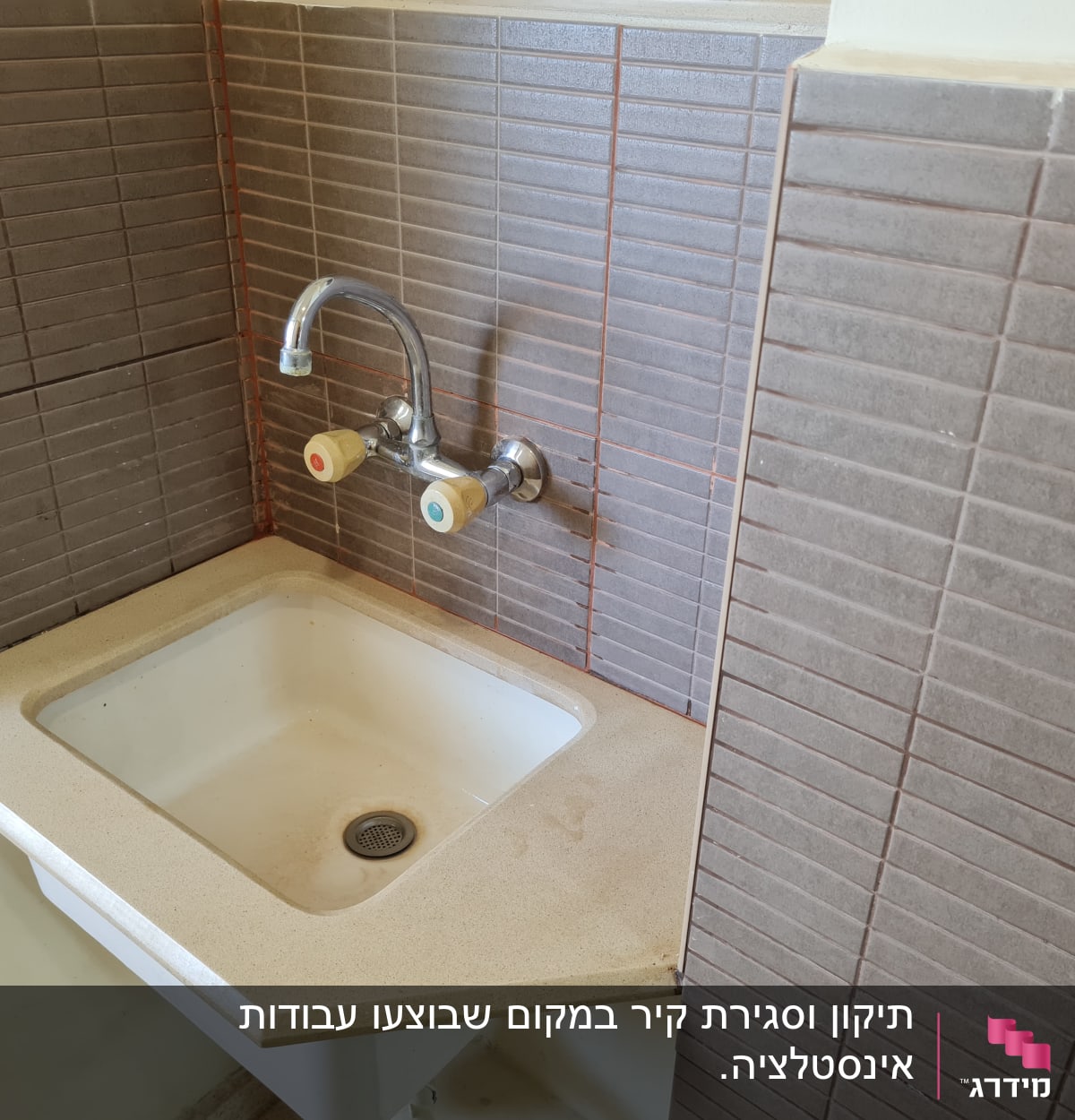 כיור עם ברז כפול ואריחים חומים